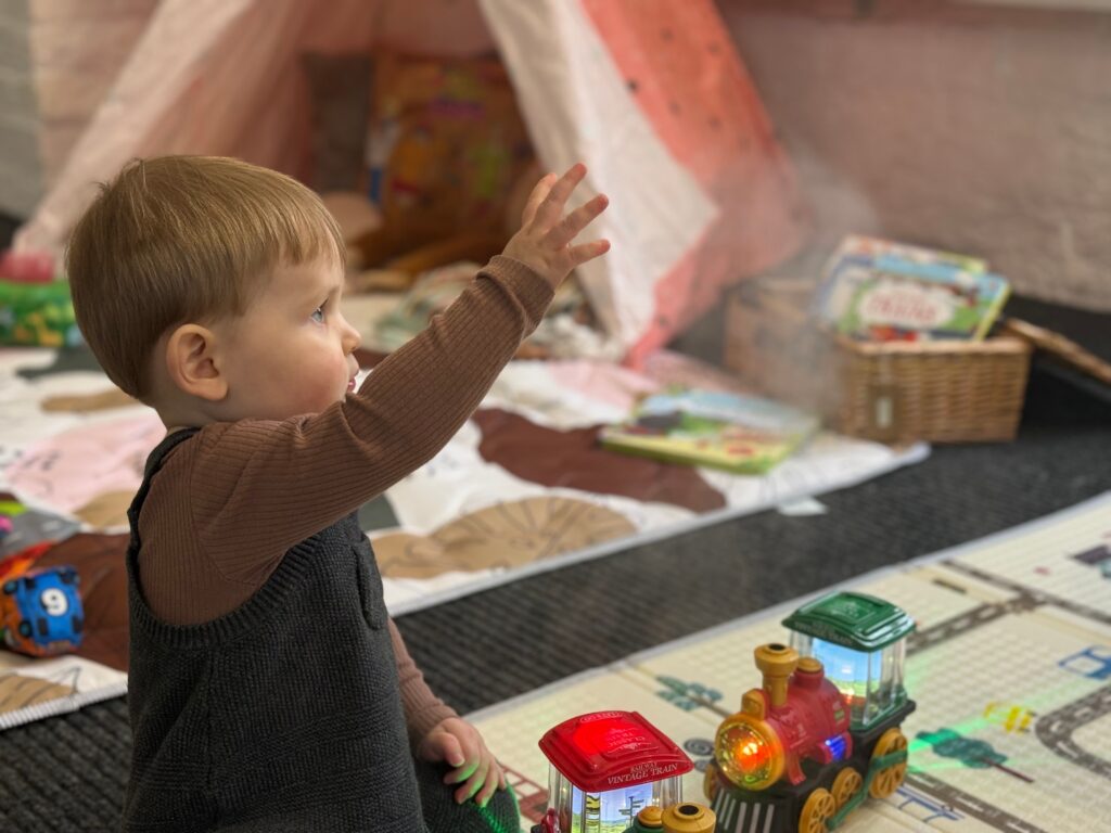 Playing with toy steam train - Adam Lewis