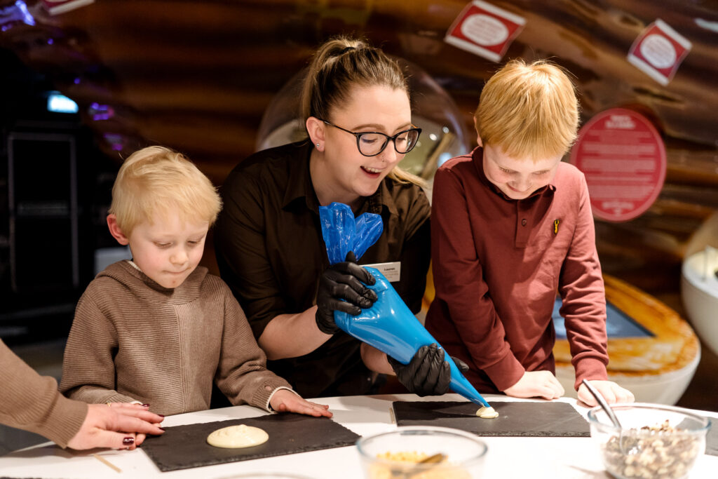 Children preparing for chocolate lolly making