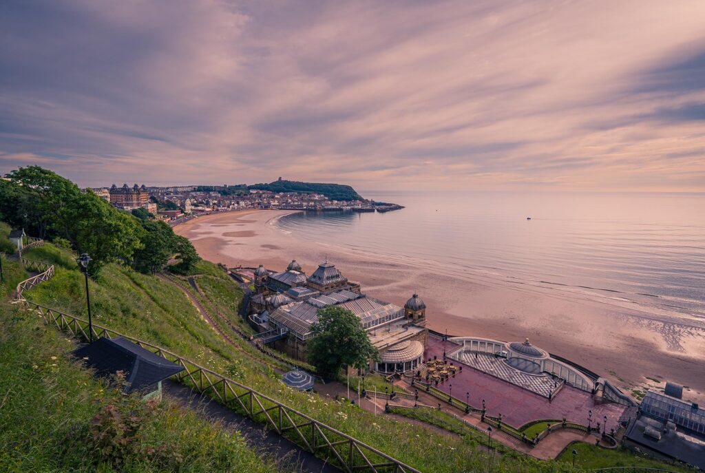 Scarborough South Bay shortly after sunrise. The clifftop vantage point offers views of the clifftop gardens, Spa, beach, Castle Headland and harbour area