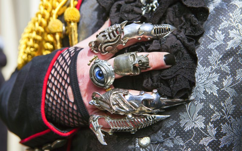 Man's hand in lacy glove and Gothic rings.